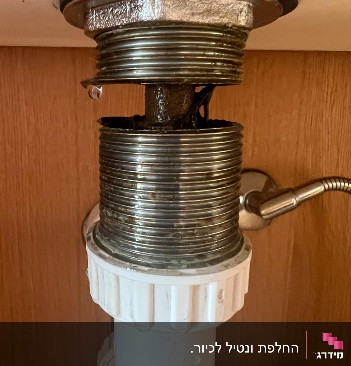 צינור מתכת עם נזילה מתחת לכיור